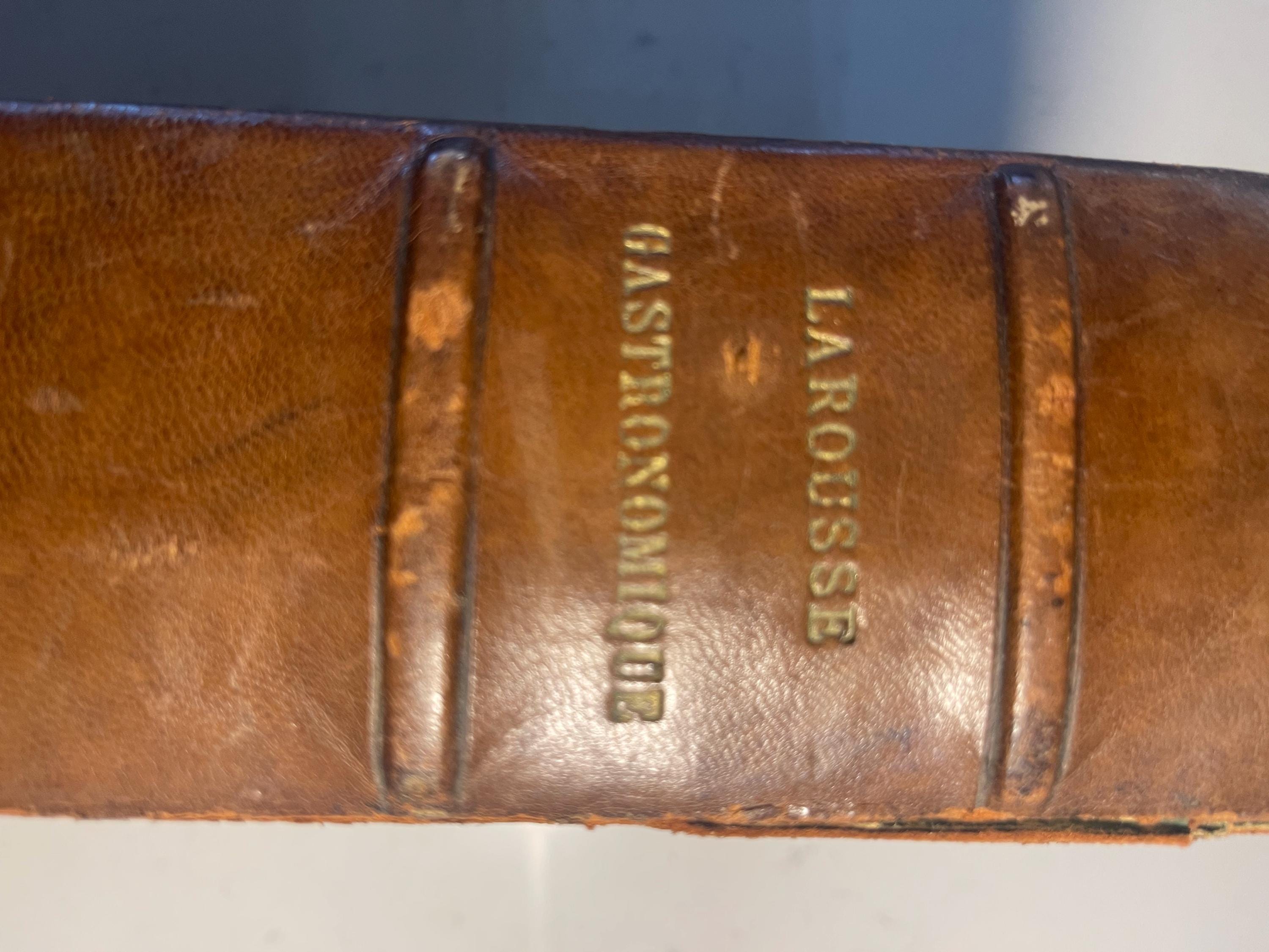 Larousse Gastronomique published in 1938 with leather spine and green marbled cover and end papers. Iconic piece of gastronomic history.