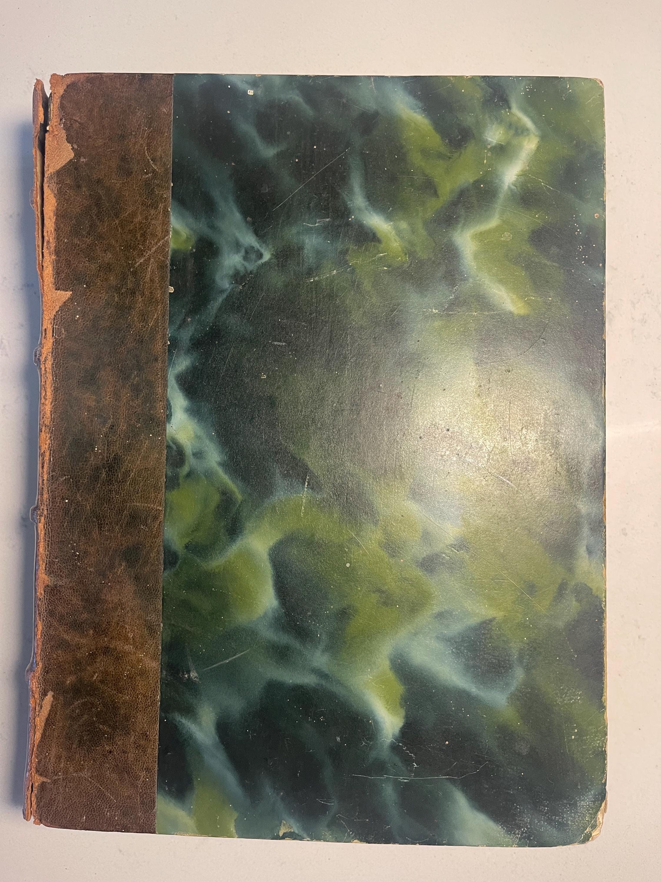 Larousse Gastronomique published in 1938 with leather spine and green marbled cover and end papers. Iconic piece of gastronomic history.