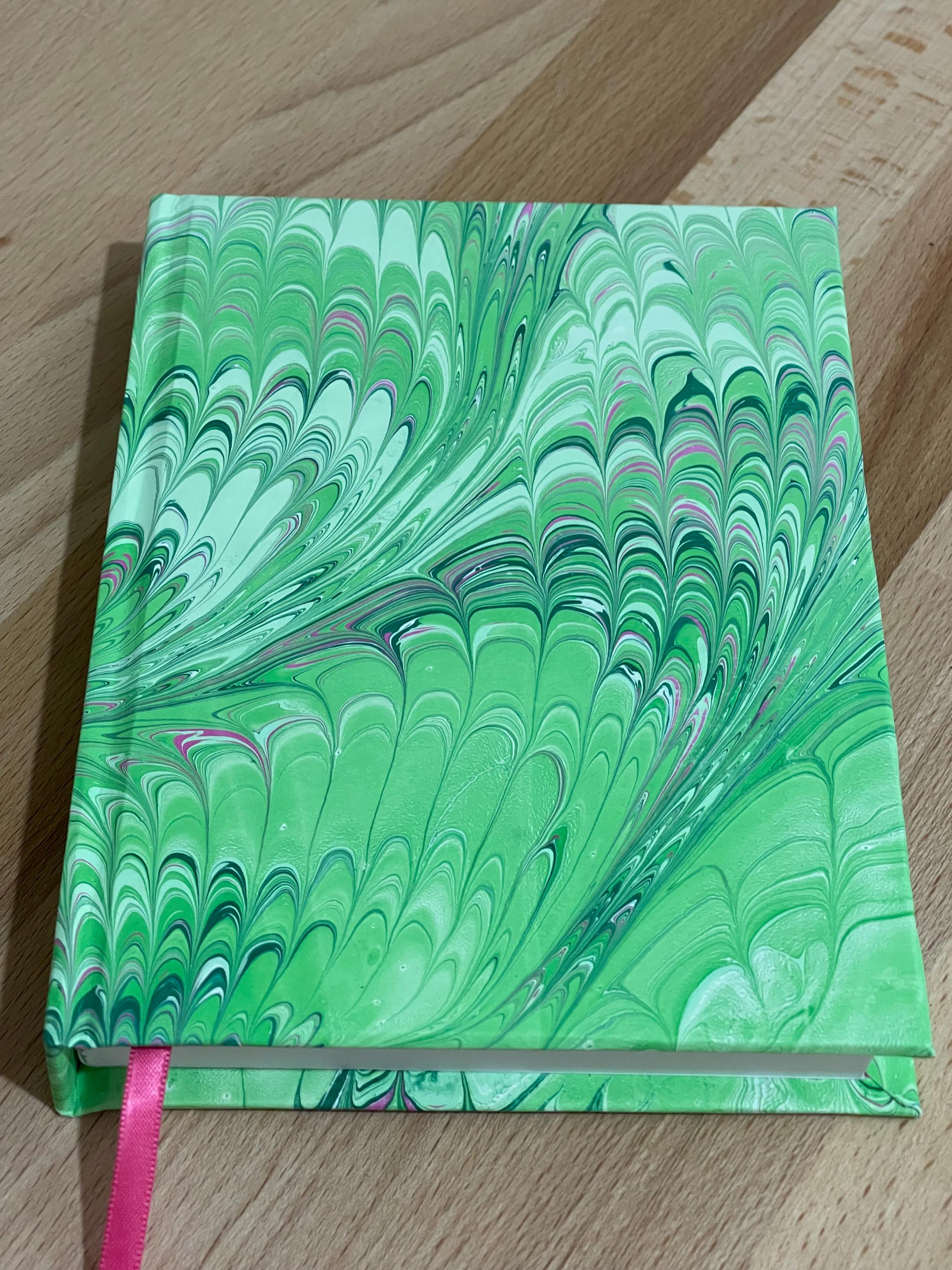 Hand marbled/painted notebook journal in a green and pink non pareil pattern with a pink book mark and recycled white lined pages