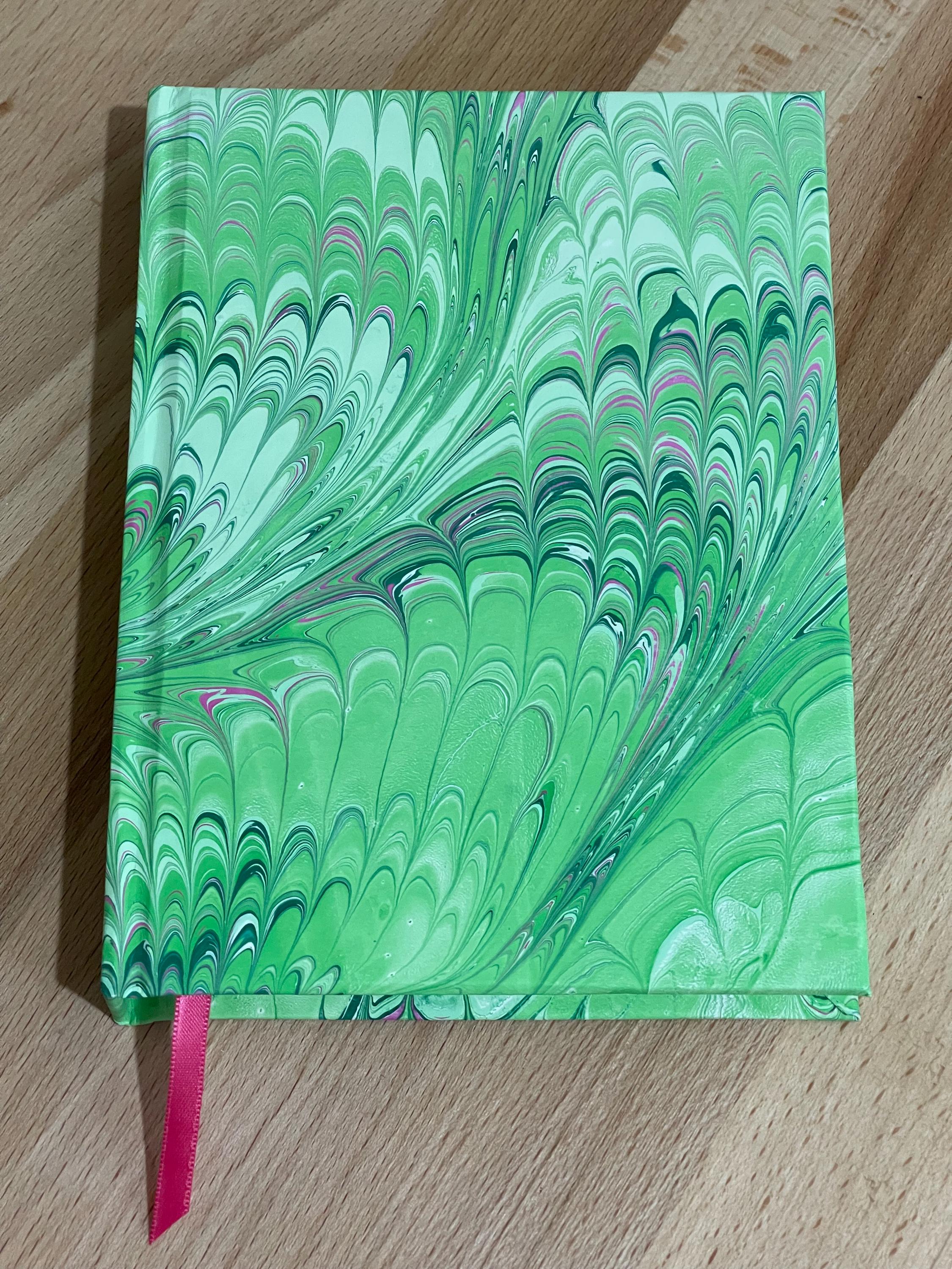 Hand marbled/painted notebook journal in a green and pink non pareil pattern with a pink book mark and recycled white lined pages