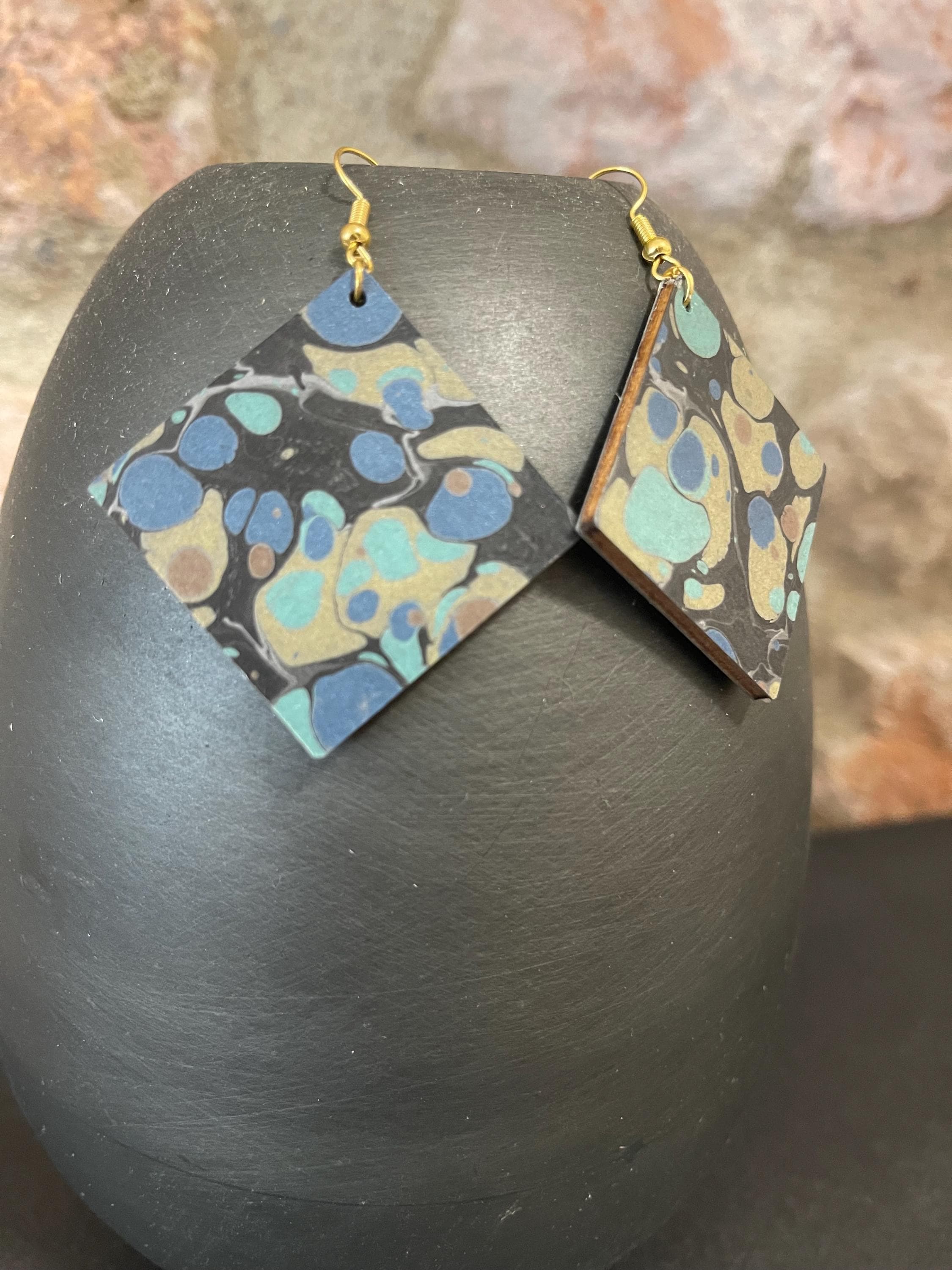 Unique square marbled dangle earrings with gold hyper allergenic hooks, stone pattern in gold, blue and green on a black background