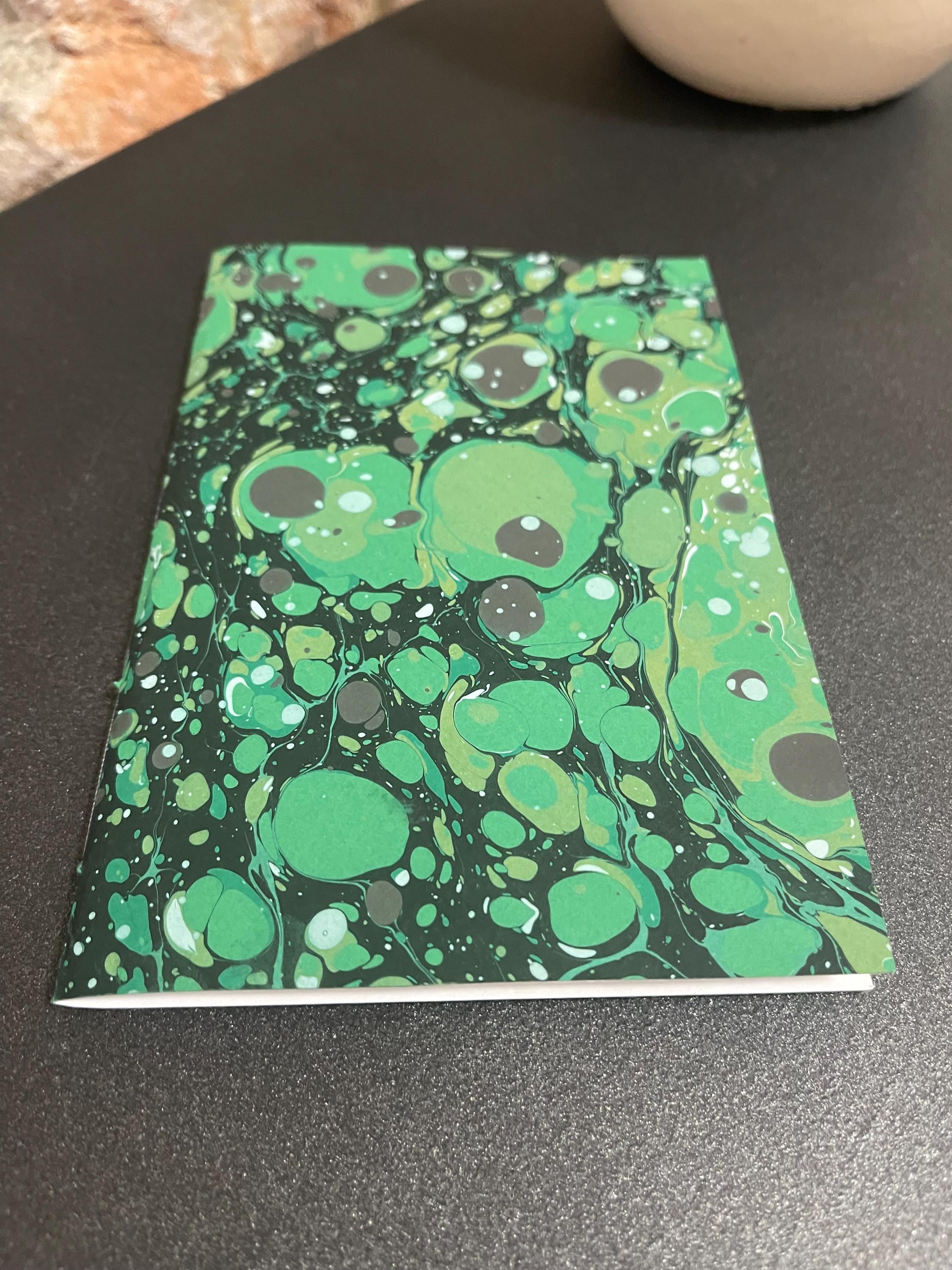 Hand sewn, hand marbled pocket notebook, A6, soft cover in greens, greys and blacks with 80 pages of lined 80g/m2 paper. Unique gift.
