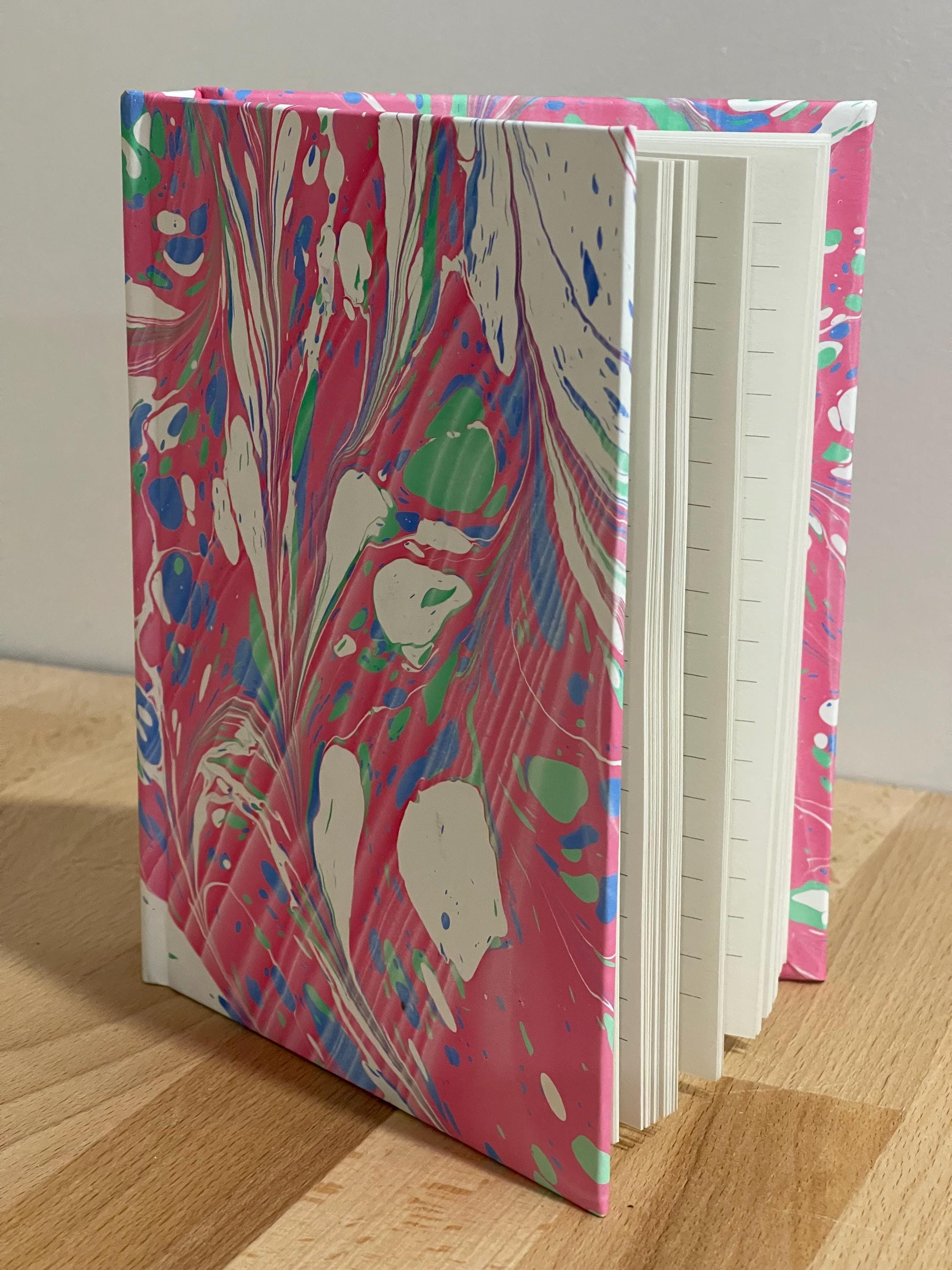 Hand marbled/painted notebook journal in deep pink with touches of blue and green with blue book mark and recycled white lined pages
