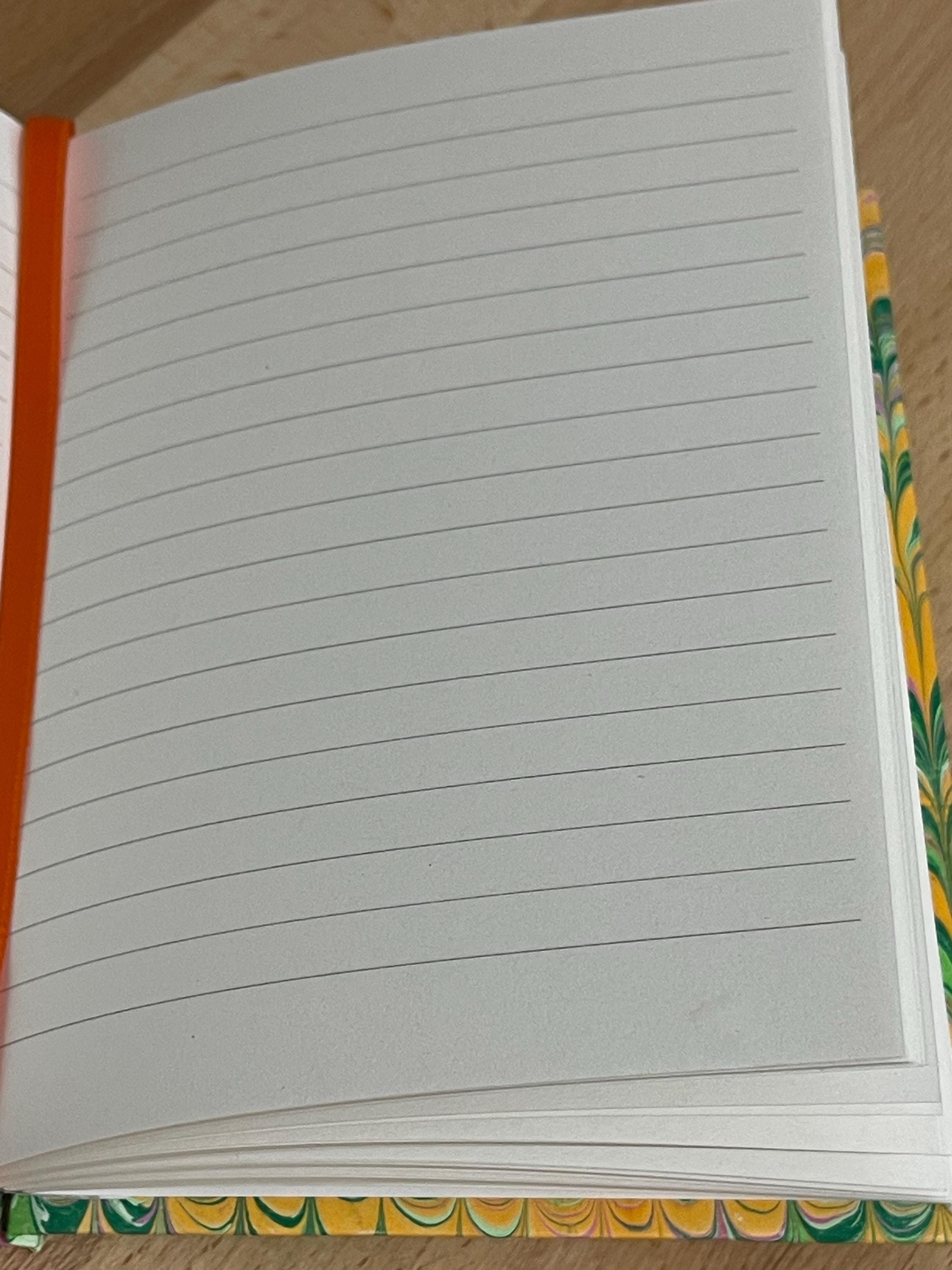 Hand marbled/painted notebook journal in a green and orange non pareil pattern with an orange book mark and recycled white lined pages