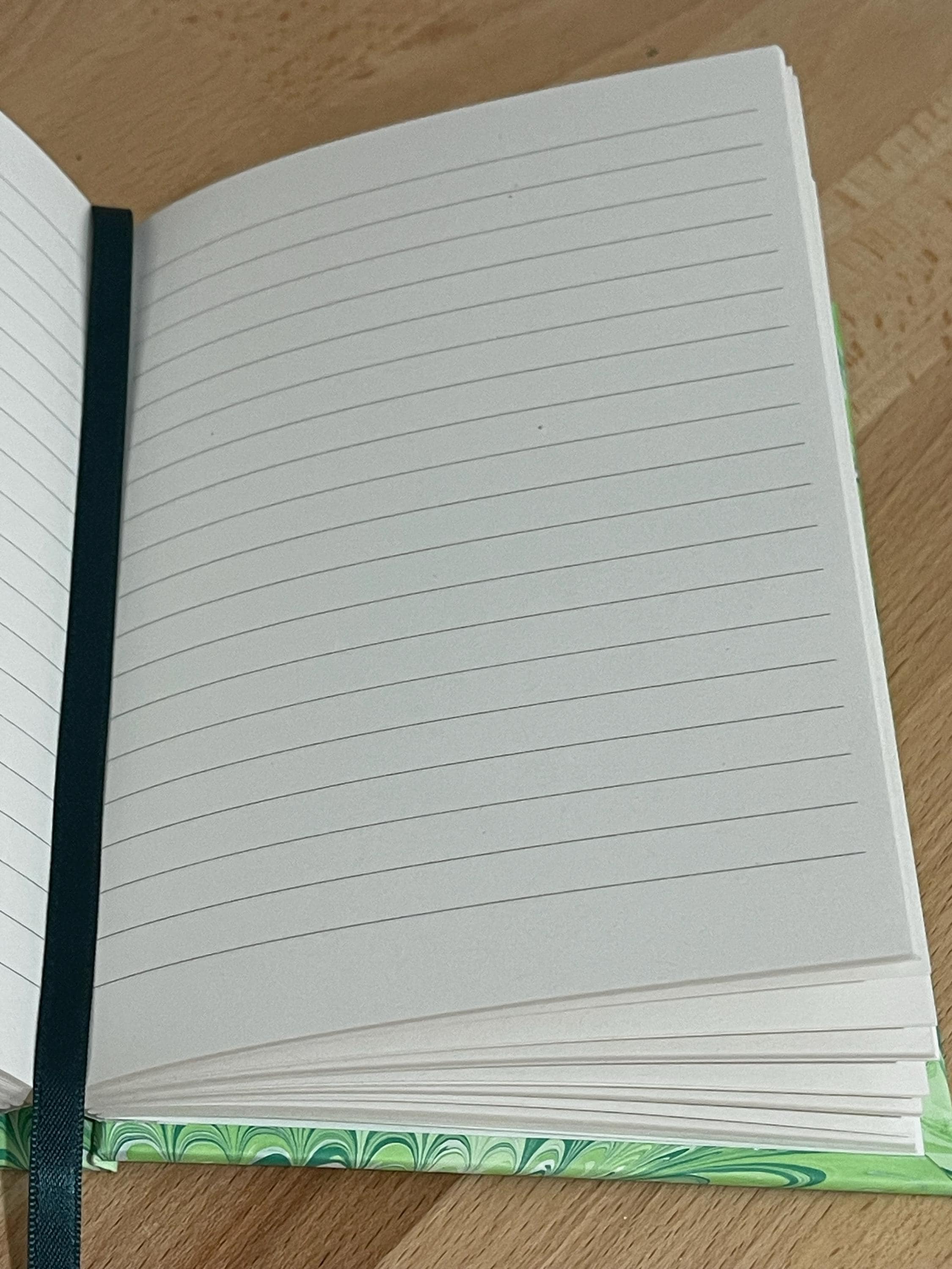 Hand marbled/painted notebook journal in a green non pareil pattern with a green book mark and recycled white lined pages